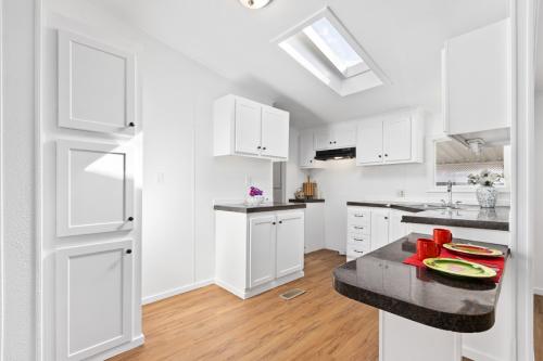 A kitchen with white cabinets and a skylight.