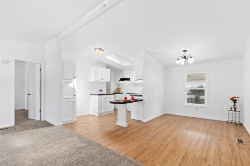 A white kitchen with hardwood floors and a skylight.