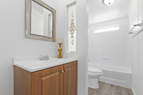 A bathroom with white walls and wood floors.