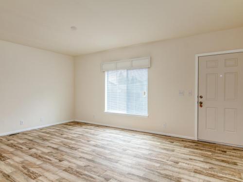 Empty room with hardwood floors and a door.